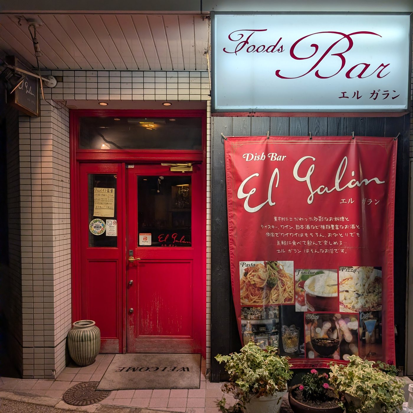 El Galán の入口。白く灯る Foods Bar の看板と、赤い扉、赤い幕