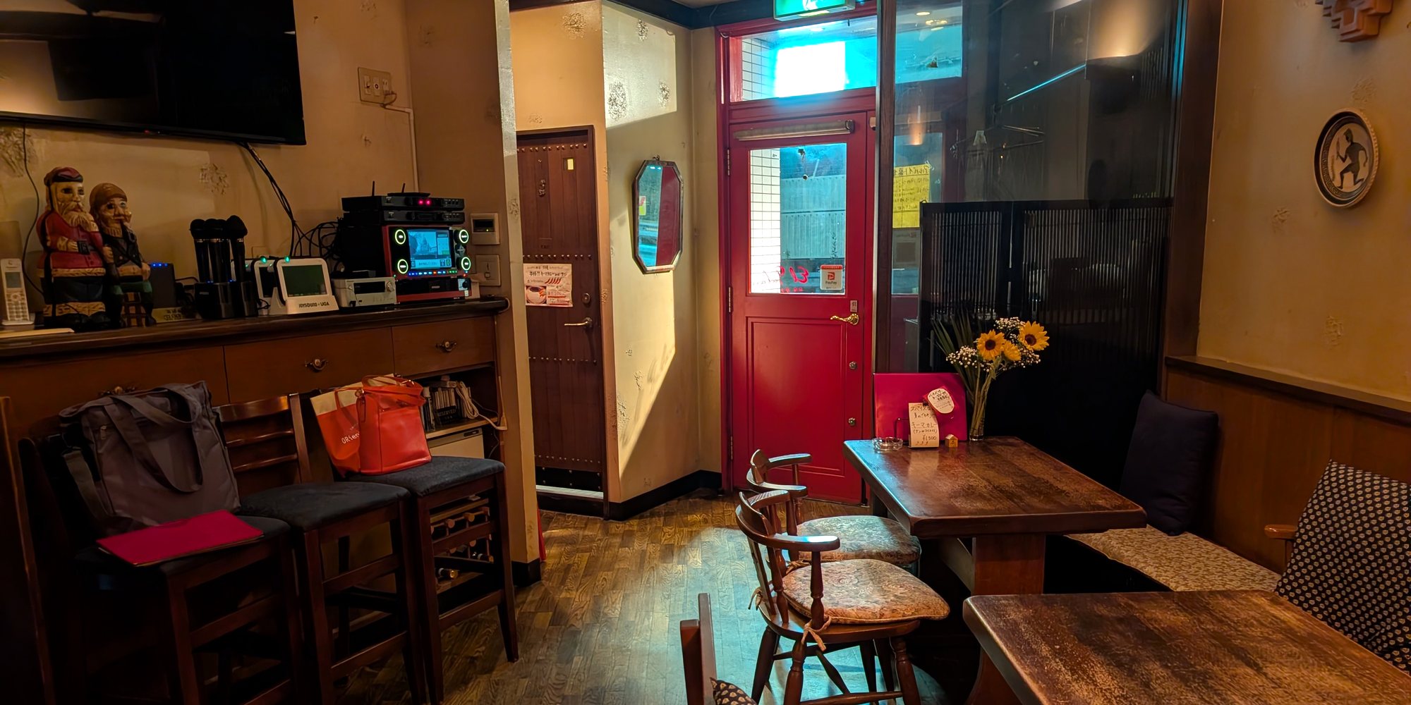 入口側を望む店内。赤い扉と、ひまわりを飾ったテーブル席